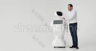 男人抚摸机器人。 和机器人的友谊。 现代机器人技术。 一个男人和一个机器人交流，